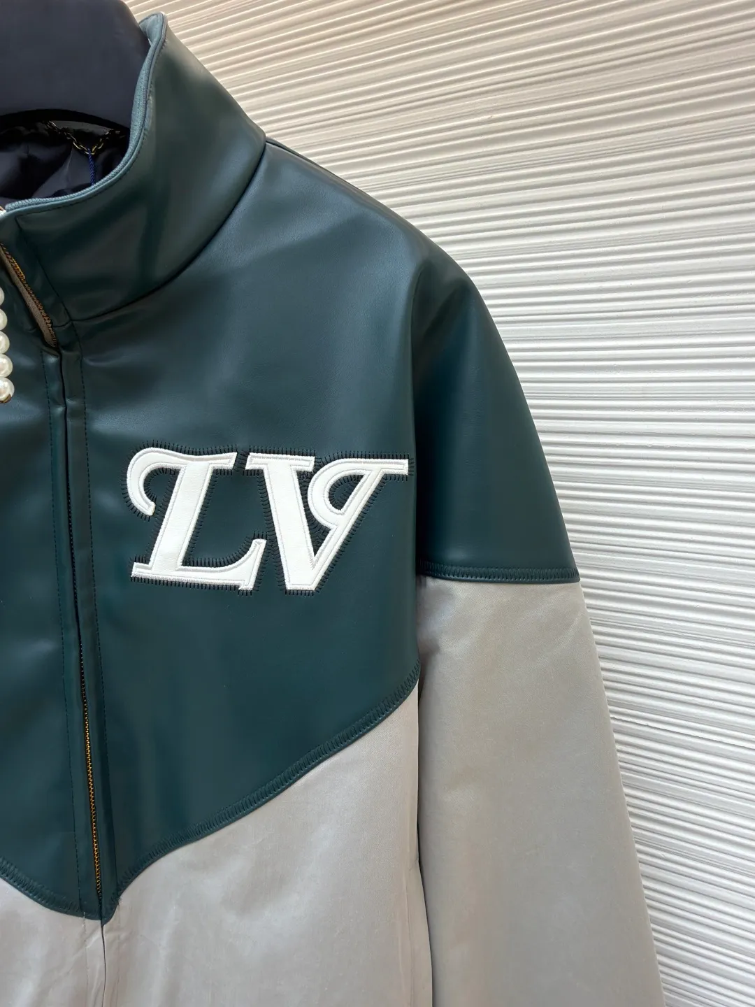 LOUIS VUITTON color-blocked sports long-sleeved jacket ●Original version: purchased and developed by 35590 ●Item number: 1681459-B80 ●Fabric: leather fabric ●Technology: intarsia production ●Color: gray-green splicing ●Version: fitted version ●Weight: about 800 grams ●Size: 46-48-50-52 ●Description: This jacket is made of high-quality genuine leather fabric. After special treatment, it feels soft and has a delicate luster. The contrasting color splicing design presents a fashionable layering. The stand-up collar structure is paired with a brand-customized metal zipper, and the zipper head is decorated with exquisite and luxurious pearls. The "LV" logo on the chest adopts three-dimensional leather embossing technology, with precise edge routing, strong three-dimensional effect and high recognition. The zipper pockets on both sides of the body are reinforced and sewn, which is practical and enhances the design. The splicing uses professional leather sewing technology, the stitch length is fine and even, and the ribbed design of the hem and cuffs fits the body shape. From the selection of genuine leather fabrics to the control of detailed craftsmanship, every process reflects LOUIS VUITTON's ultimate pursuit of craftsmanship precision and luxury style. It not only shows the high-end texture of leather items, but also highlights the brand design language through contrasting colors and three-dimensional logos. It is a fusion of leather craftsmanship and fashion design. The overall wiring is straight and delicate, the fabric is comfortable and soft, and the color is consistent without color difference. It can be matched with the same style to create a fashionable look and control various occasions. Customized accessories, complete with three standards, same style for men and women!